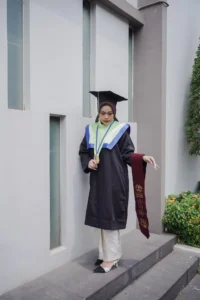 Aila Stikes Purwokerto Aston sedang berfoto dalam pakaian wisuda.