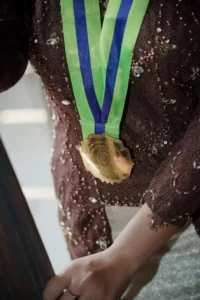 Aila Stikes Purwokerto Aston memenangkan gelar wisuda dengan medali di lehernya.