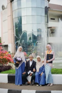Wisudawan Kristina UMP berdiri di depan fonsai.