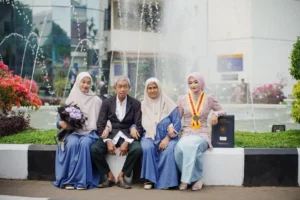 Krismina UMP, Universitas Muhammadiyah Purwokerto, sedang berfoto bersama keluarga di depan sebuah fountain.
