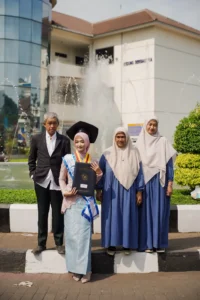Kristina UMP universitas Muhammadiyah Purwokerto sedang berpose di depan sebuah fountains.