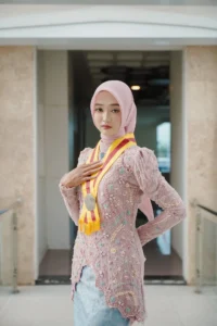 Kristina UMP di universitas Muhammadiyah Purwokerto memamerkan medali dalam foto berpakaian merah.
