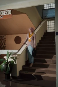 Kristina UMP, seorang wanita dalam pakaian formal berdiri di atas tangga.
