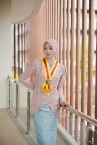 Kristina UMP, Universitas Muhammadiyah Purwokerto, memamerkan medali di tengah pertandingan wisuda.