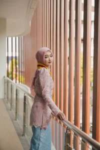 Seorang wanita berpakaian berwarna merah sedang menatap sisi dengan lehernya terlebih dahulu, tampaknya sedang berada di sekitar universitas Muhammadiyah Purwokerto.