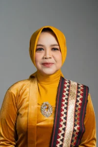 Seorang wanita berpakaian pakaian pendek berwarna kuning dan berhijab berdiri di foto profil kepala Kementerian Kebudayaan dan Pariwisata Provinsi Purbalingga.