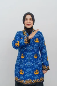 Seorang wanita berdiri dengan tangan di atas kepala, memakai jaket polos berwarna biru dan emas.