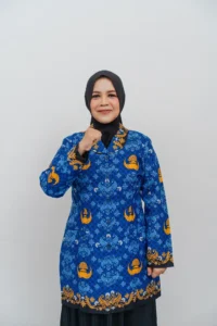 Seorang wanita berpakaian pakaian berwarna biru dan oranye sedang mengambil foto.