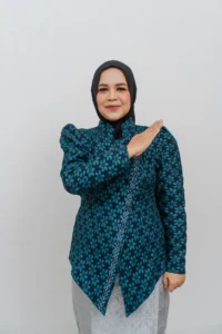 Seorang wanita dalam pakaian biru dan putih sedang memberi tangan atas kepala Kementerian Kebudayaan dan Pariwisata Provinsi Purbalingga.